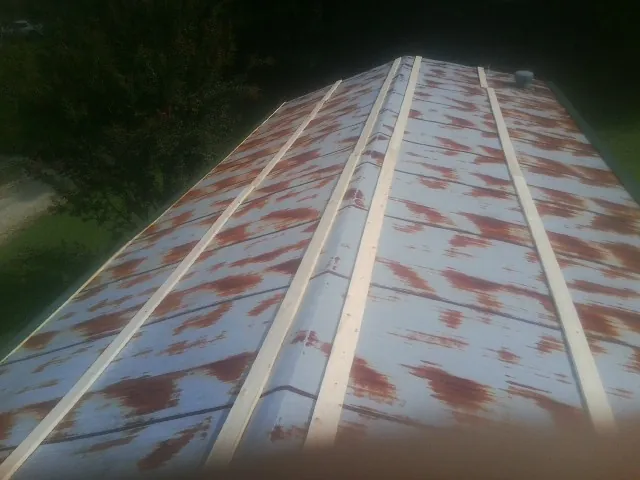 Rusted metal roof panels with new wood purlins before replacement — Storm Damage Roof Repair in Bellport by Roofing Brothers
