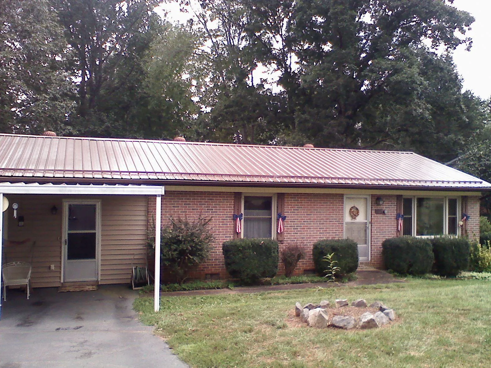 Bronze metal roof and carport on a brick ranch home — Roof Repair work by our crew in Bellport